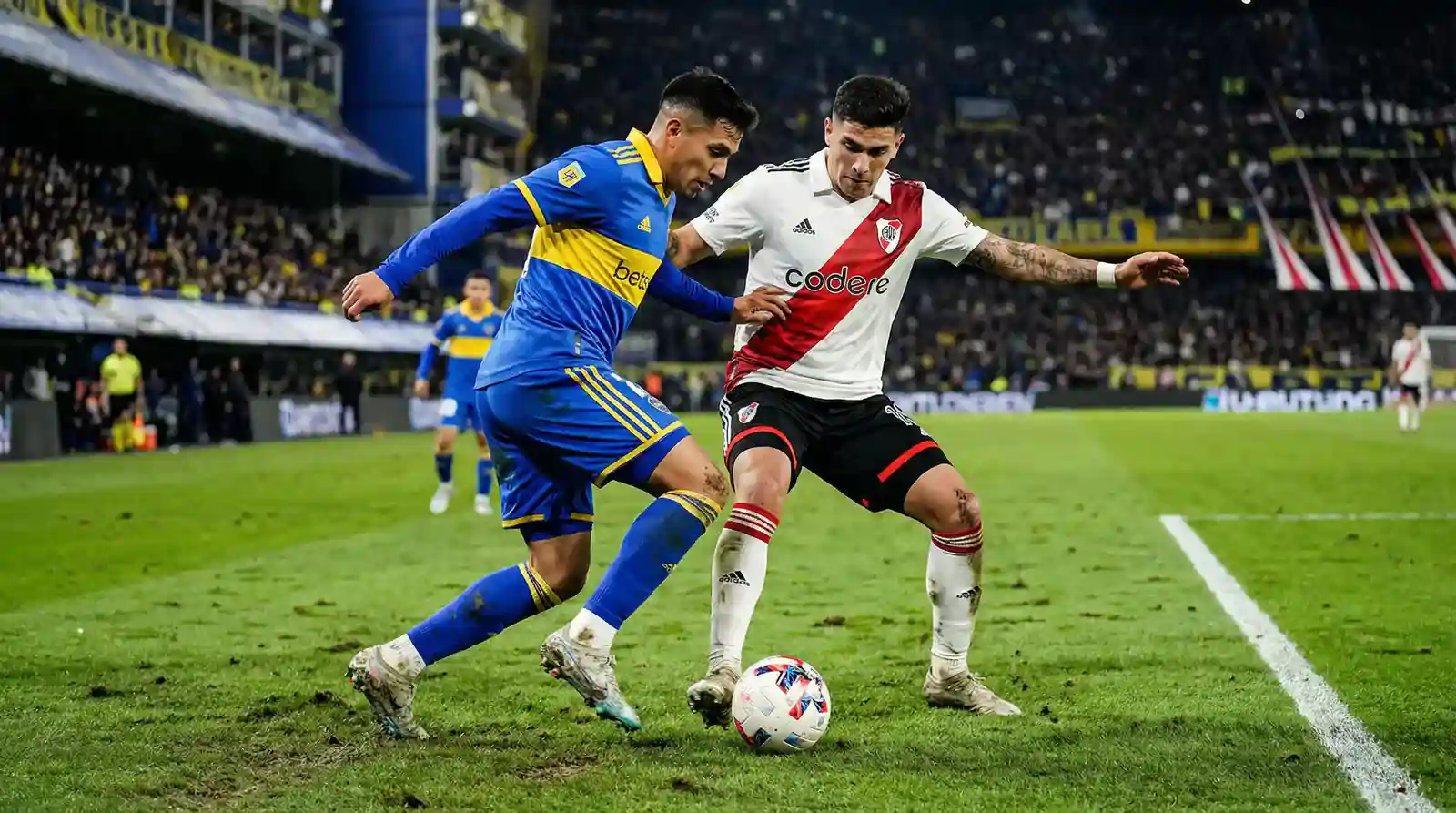 Jugadores de fútbol argentino disputando un balón en un partido de la Liga Profesional sobre césped natural